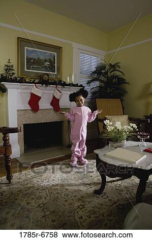 A young girl in pajamas by the fireplace waiting for Santa View Large Photo Image Stock Photo - A young girl in pajamas by the fireplace waiting for Santa. Fotosearch