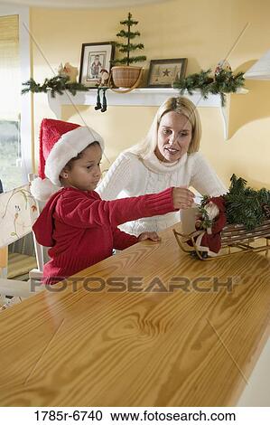 Stock Image - An inter-racial family sitting at the kitchen counter and table. Fotosearch