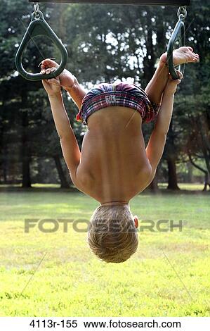 Boy hanging on gymnastic rings in a park View Large Photo Image Stock Photography - Boy hanging on gymnastic rings in a park. Fotosearch