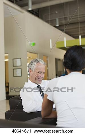 Business discussions in office lobby View Large Photo Image Stock Image - Business discussions in office lobby. Fotosearch