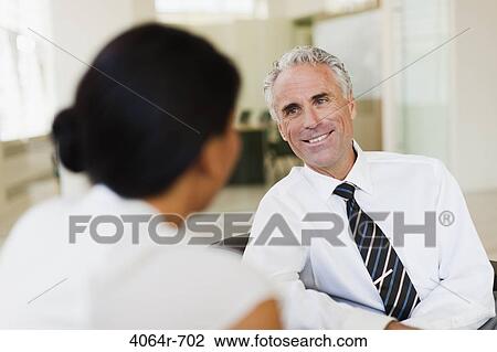 Stock Image - Business discussions in office lobby. Fotosearch