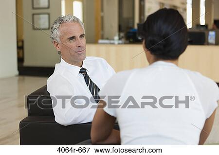 Business discussions in office lobby View Large Photo Image Stock Photo - Business discussions in office lobby. Fotosearch