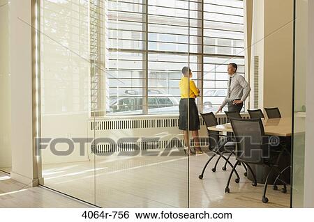 Businessman and woman consulting in boardroom View Large Photo Image Stock Photograph - Businessman and woman consulting in boardroom. Fotosearch