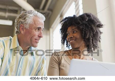 Stock Image - Businessman and woman working in office. Fotosearch