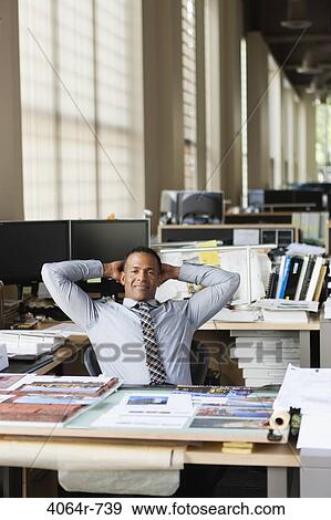 Businessman at desk in office View Large Photo Image Stock Photo - Businessman at desk in office. Fotosearch