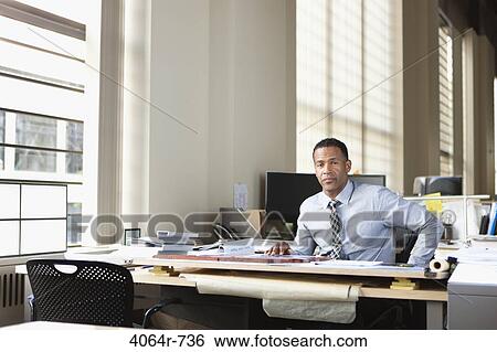 Stock Photograph - Businessman at desk in office. Fotosearch