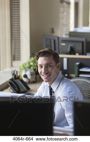 Businessman at his desk in office View Large Photo Image Picture - Businessman at his desk in office. Fotosearch