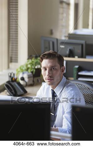 Businessman at his desk in office View Large Photo Image Stock Image - Businessman at his desk in office. Fotosearch