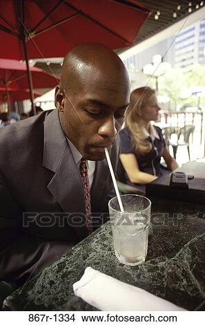 Businessman drinking a beverage with a straw View Large Photo Image Picture - Businessman drinking a beverage with a straw. Fotosearch