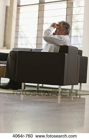 Businessman waiting in office lobby View Large Photo Image Stock Image - Businessman waiting in office lobby. Fotosearch
