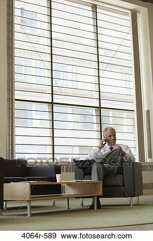 Businessman waiting in office lobby View Large Photo Image Stock Photo - Businessman waiting in office lobby. Fotosearch
