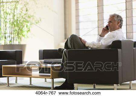 Businessman waiting in office lobby View Large Photo Image Stock Photo - Businessman waiting in office lobby. Fotosearch