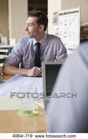Businessman working on project at office View Large Photo Image Stock Photo - Businessman working on project at office. Fotosearch