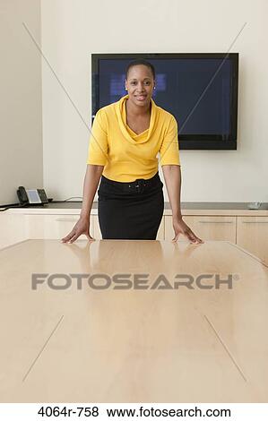 Stock Photo - Businesswoman standing at conference table, portrait. Fotosearch