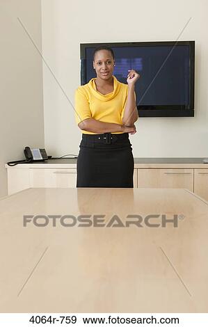 Stock Photo - Businesswoman standing at conference table, portrait. Fotosearch