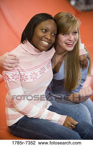Cheerful teenage girlfriends sitting together View Large Photo Image Stock Image - Cheerful teenage girlfriends sitting together. Fotosearch