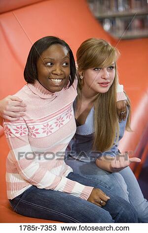 Cheerful teenage girlfriends sitting together View Large Photo Image Stock Image - Cheerful teenage girlfriends sitting together. Fotosearch