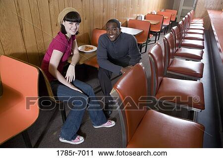 Cheerful young inter-racial couple sitting in a pizza parlor View Large Photo Image Stock Image - Cheerful young inter-racial couple sitting in a pizza parlor. Fotosearch