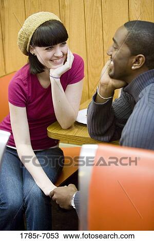 Cheerful young inter-racial couple sitting in a cafe View Large Photo Image Stock Image - Cheerful young inter-racial couple sitting in a cafe. Fotosearch