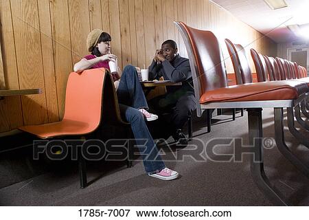 Stock Photo - Cheerful young inter-racial couple sitting in a diner. Fotosearch