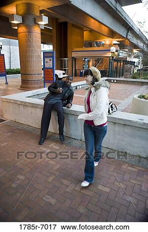 Cheerful young inter-racial couple outside a train station View Large Photo Image Stock Photo - Cheerful young inter-racial couple outside a train station. Fotosearch
