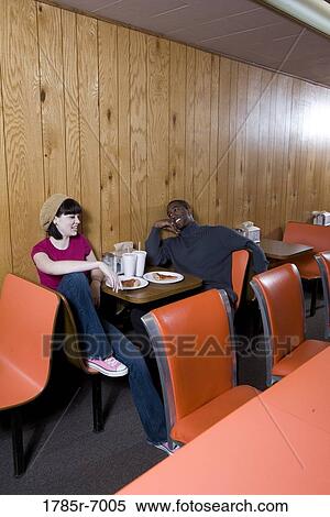 Cheerful young inter-racial couple sitting in a pizza parlor View Large Photo Image Stock Photography - Cheerful young inter-racial couple sitting in a pizza parlor. Fotosearch