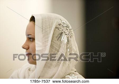 Close-up of a contemplative young woman wearing a head scarf View Large Photo Image Stock Photo - Close-up of a contemplative young woman wearing a head scarf. Fotosearch