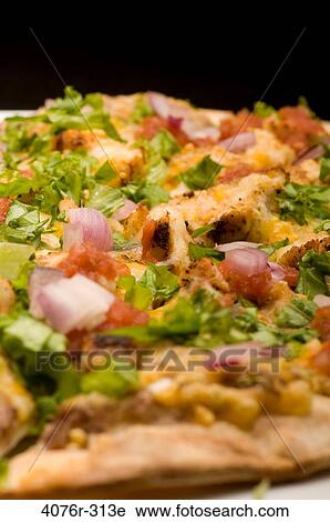 Stock Image - Close-up of a Mexican pizza with toppings of vegetables. Fotosearch