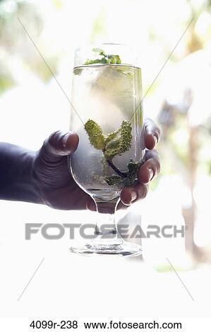 Close-up of a person's hand holding a glass of Mojito View Large Photo Image Stock Photo - Close-up of a person's hand holding a glass of Mojito. Fotosearch