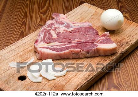 Stock Image - Close-up of a raw steak on a cutting board. Fotosearch