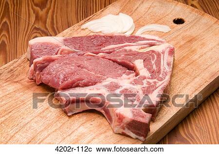 Stock Image - Close-up of a raw steak on a cutting board. Fotosearch