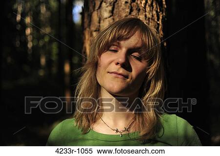 Close-up of a woman with eyes closed relaxing in forest View Large Photo Image Stock Photography - Close-up of a woman with eyes closed relaxing in forest. Fotosearch