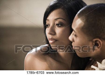 Stock Image - Close-up of a young woman sitting close to a young man. Fotosearch