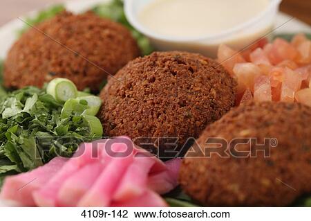 Stock Image - Close-up of Falafel balls with tahini dipping sauce. Fotosearch