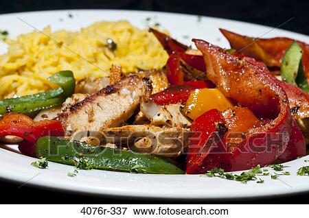 Close up of fried chicken with peppers and rice View Large Photo Image Stock Photo - Close up of fried chicken with peppers and rice. Fotosearch