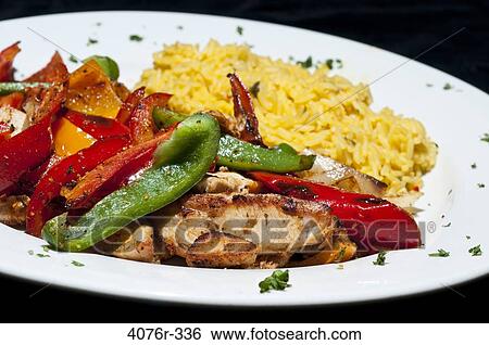 Stock Photograph - Close up of fried chicken with peppers and rice. Fotosearch