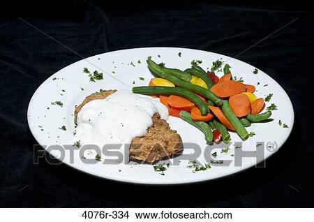 Picture - Close up of fried chicken with veggies. Fotosearch