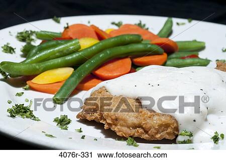 Stock Image - Close up of fried chicken with veggies. Fotosearch
