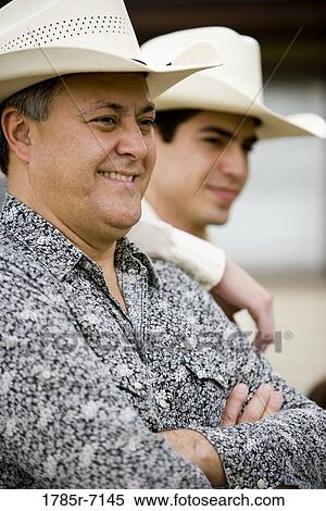 Stock Photography - Close-up of Tex-Mex father and son standing together. Fotosearch