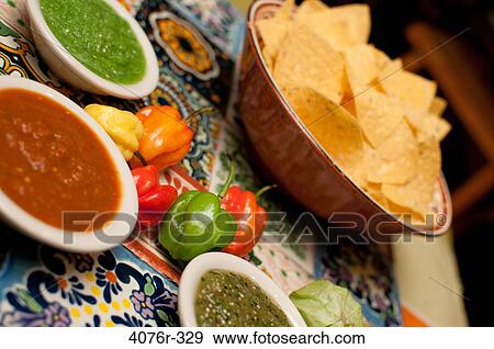 Close up of tortilla chips, peppers and salsa on colored tiles View Large Photo Image Stock Photo - Close up of tortilla chips, peppers and salsa on colored tiles. Fotosearch