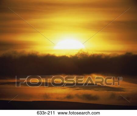 Stock Image - Clouds in the sky at sunset. Fotosearch