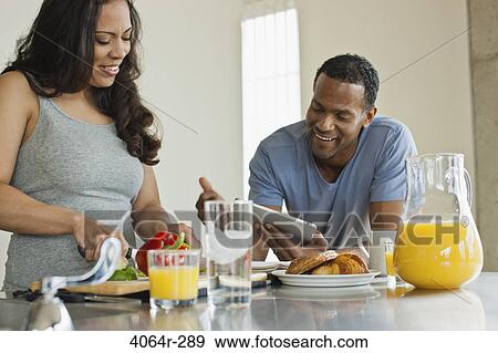 Couple making breakfast in loft apartment View Large Photo Image Stock Photo - Couple making breakfast in loft apartment. Fotosearch