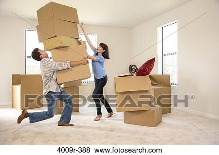 Couple moving into new house, man carrying several boxes View Large Photo Image Stock Photo - Couple moving into new house, man carrying several boxes. Fotosearch