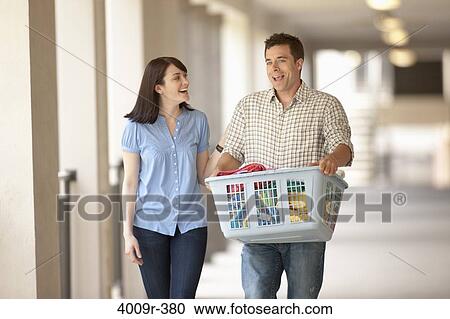Stock Image - Couple on their way do to laundry. Fotosearch