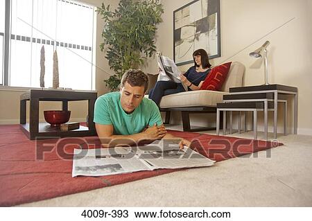 Couple relaxing at home, reading newspaper View Large Photo Image Stock Image - Couple relaxing at home, reading newspaper. Fotosearch