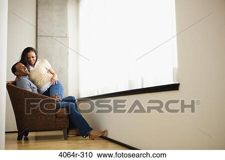 Stock Image - Couple relaxing in loft apartment. Fotosearch