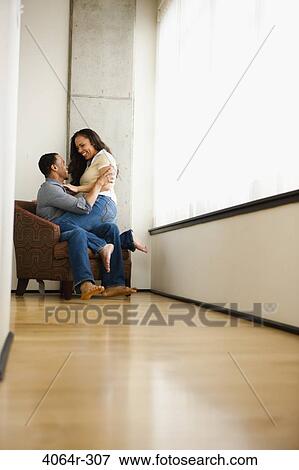 Stock Photo - Couple relaxing in loft apartment. Fotosearch