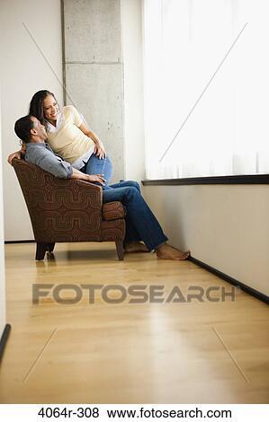 Stock Photo - Couple relaxing in loft apartment. Fotosearch