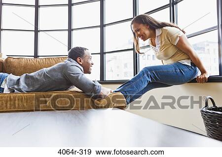 Stock Photo - Couple relaxing in loft apartment. Fotosearch