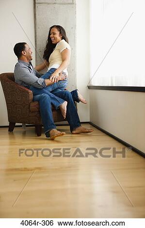Stock Photograph - Couple relaxing in loft apartment. Fotosearch